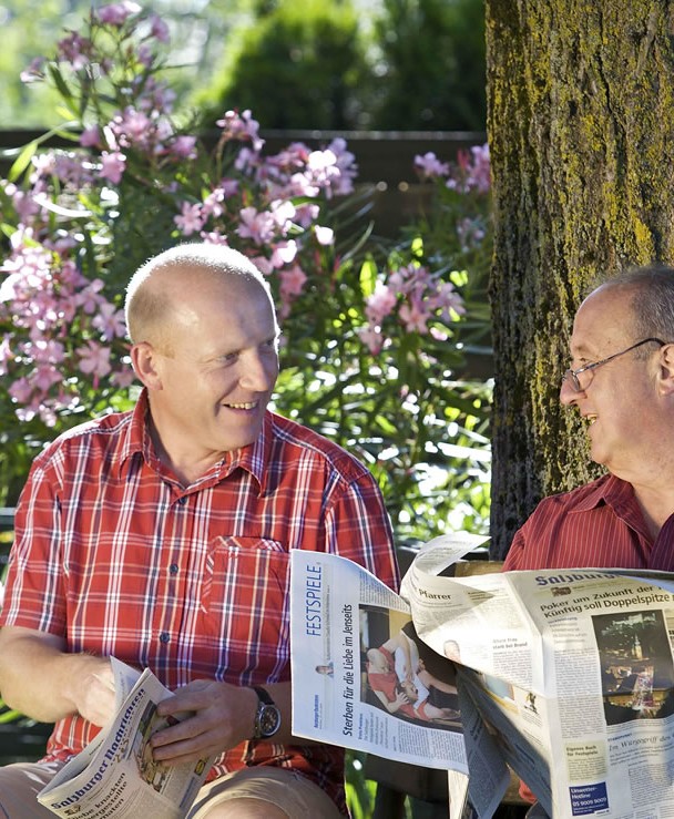 Senioren beim Zeitung lesen im Garten